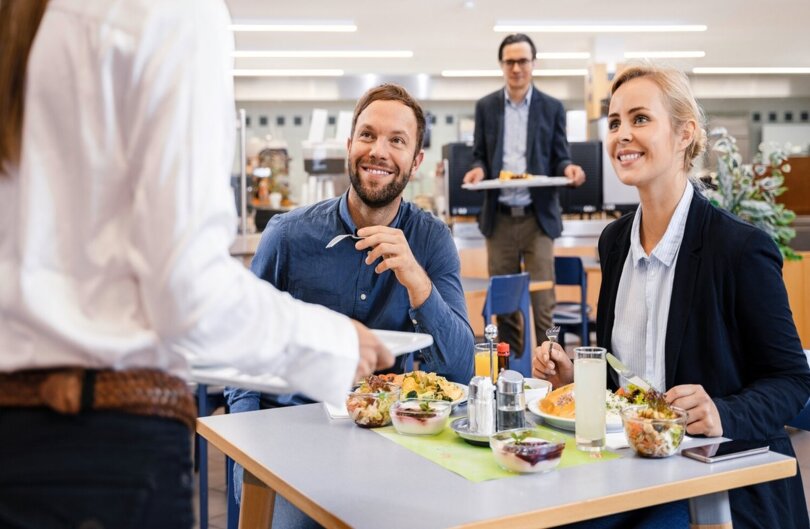 Un homme et une femme déjeunent à la cantine - Repas équilibré dans un cadre scolaire
