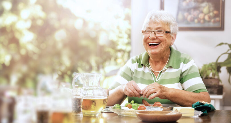 Femme âgée souriante dégustant une collation - Nutrition équilibrée pour seniors