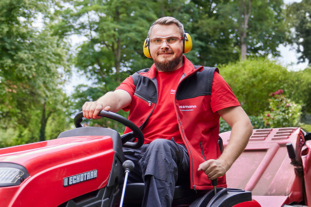 Employé à l'entretien des espaces verts utilisant un tracteur tondeuse – Une expertise professionnelle pour des espaces extérieurs impeccables et bien entretenus