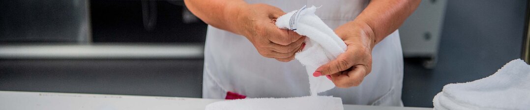 Agent de blanchisserie pliant du linge avec précision – Garantissez un service de qualité pour des vêtements impeccables et bien entretenus