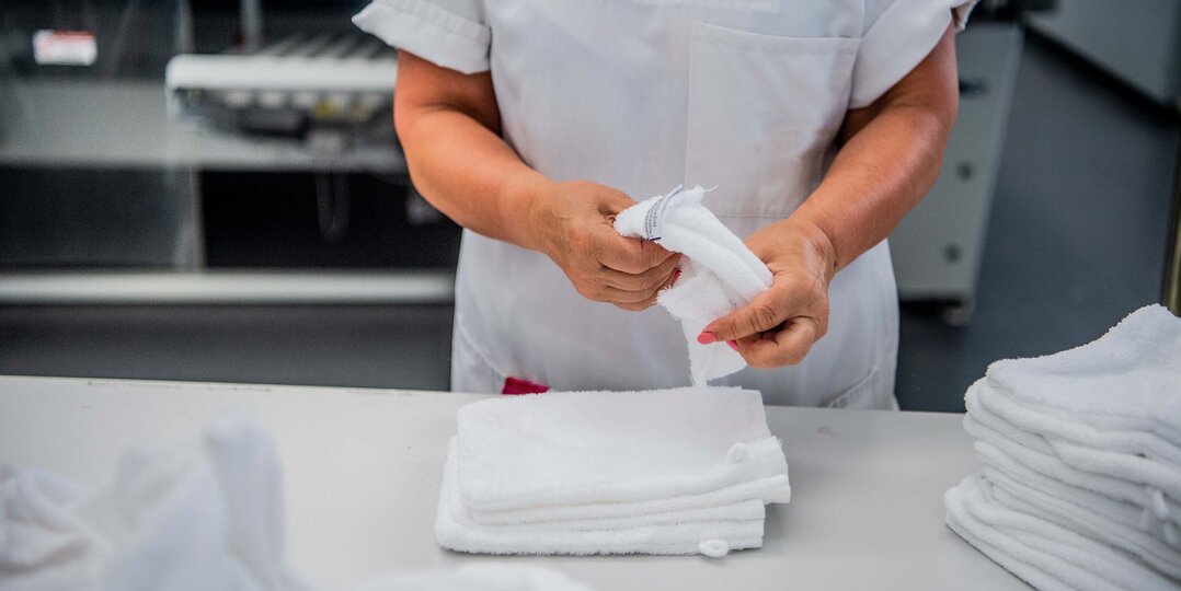 Agent de blanchisserie pliant du linge avec précision – Garantissez un service de qualité pour des vêtements impeccables et bien entretenus