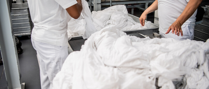 Agent de blanchisserie triant du linge avec précision – Une étape essentielle pour garantir un service de qualité et des textiles impeccables