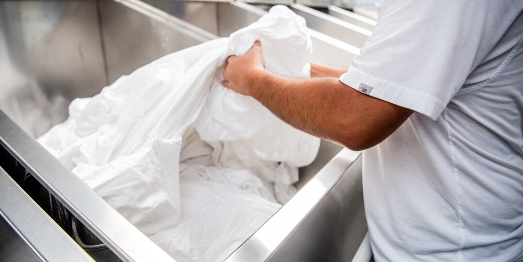 Agent de blanchisserie triant le linge propre avec soin