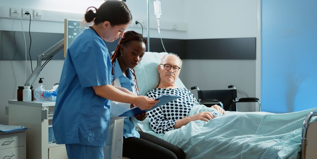 Service de blanchisserie Dussmann Lavador répondant aux normes strictes du secteur médical, garantissant une désinfection optimale du linge hospitalier et une qualité irréprochable pour la protection des patients et du personnel soignant | © <a href="https://www.freepik.com/free-photo/african-american-doctor-talking-sick-patient-bed-hospital-ward-treating-health-problems-injury-old-man-asking-medic-nurse-about-intensive-care-illness-recovery_20717490.htm">Image by DC Studio on Freepik</a>