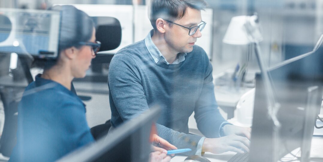 Homme et femme travaillant ensemble sur un ordinateur dans un bureau