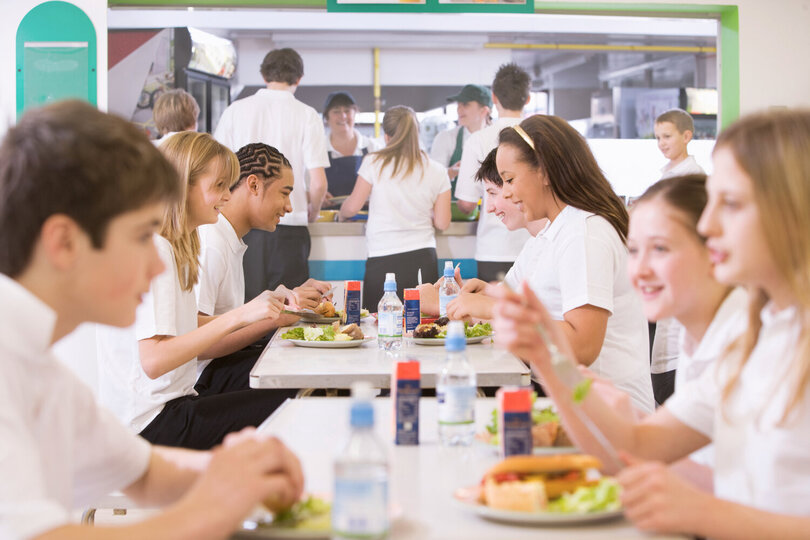 Étudiants partageant un repas à la cantine scolaire - Alimentation équilibrée pour tous